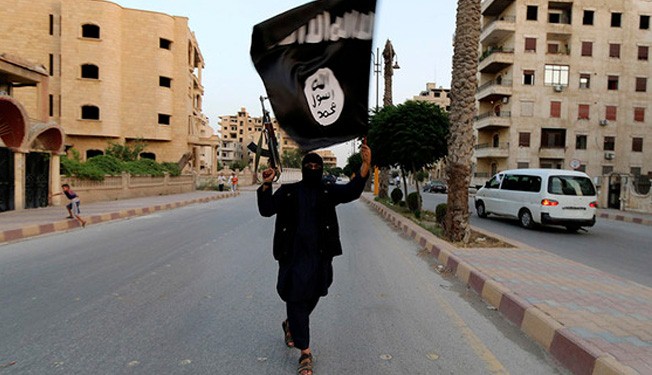 A terrorist waves an ISIL flag in Raqqa, June 29, 2014.