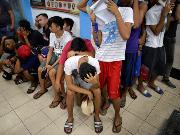 People wait to be processed at a police station, after they were detained in a police "One Time Bigtime" operation against illegal drugs in metro Manila, Philippines October 12, 2016. REUTERS/Ezra Acayan