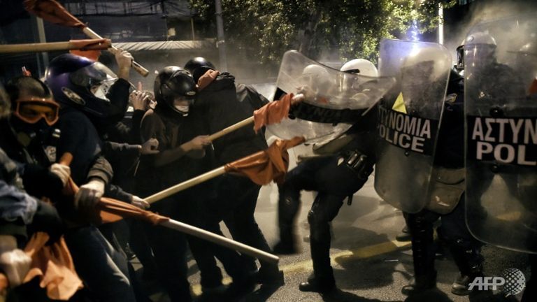 demonstrators-holding-red-flags-clash-with-greek-riot-police