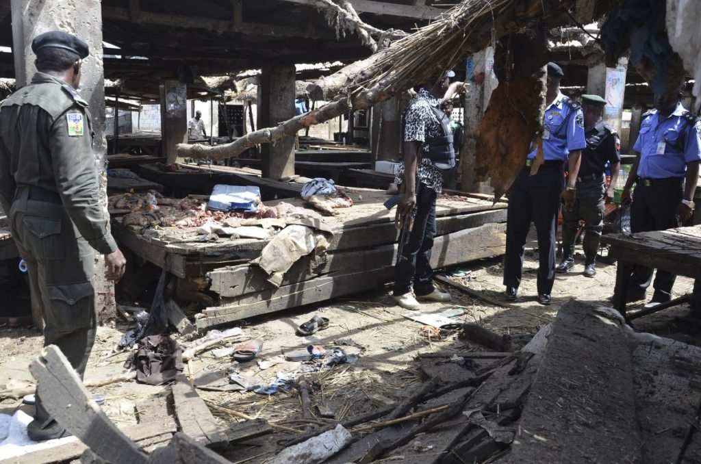 Police officers inspect the site of  a suicide bomb attack at a market in Maiduguri , Nigeria, Tuesday, June 2, 2015.  Boko Haram attacked the northeastern Nigerian city of Maiduguri on Tuesday with deafening explosions from the west and a suicide bombing near the center that witnesses said killed as many as 20 people.  (AP Photo/Jossy Ola)