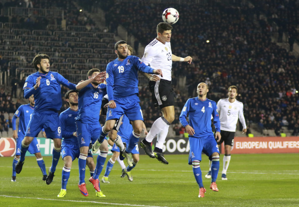 Germany's Mario Gomes, centre, heads for the ball during their World Cup Group C qualifying match against Azerbaijan at the Tofig Bahramov Stadium in Baku, Azerbaijan, Sunday March 26, 2016. (AP Photo/Aziz Karimov)