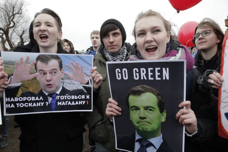 Protesters hold posters depicting Russian Prime Minister Dmitry Medvedev at Marsivo Field in St.Petersburg, Russia, Sunday, March 26, 2017. Thousands of people crowded in St.Petersburg on Sunday for an unsanctioned protest against the Russian government, the biggest gathering in a wave of nationwide protests that were the most extensive show of defiance in years. The poster reads: "If you stole for Toscana, prepare for Magadan [a region of prisons in Russia]"  (AP Photo/Dmitri Lovetsky)