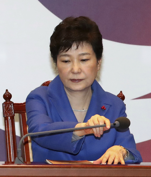 South Korean President Park Geun-hye adjusts a microphone during an emergency Cabinet meeting at the presidential office in Seoul, South Korea, Friday, Dec. 9, 2016. South Korean lawmakers earlier on Friday impeached Park, a stunning and swift fall for the country's first female leader amid protests that drew millions into the streets in united fury. (Baek Sung-ryul/Yonhap via AP)