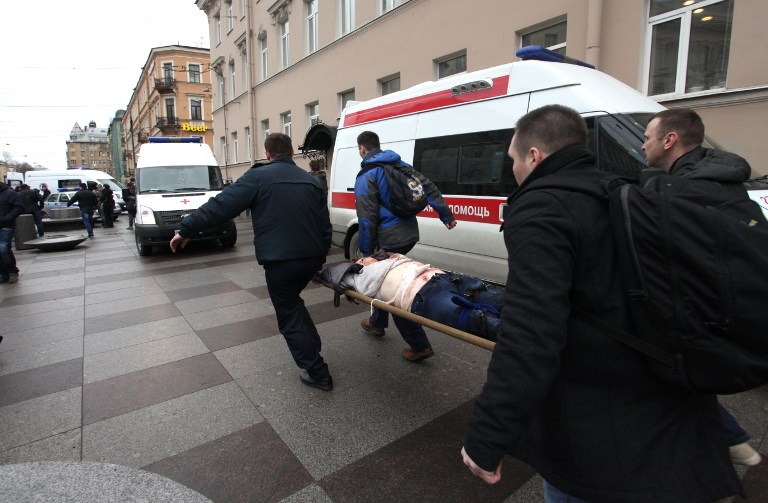 Men carry an injured person on a stretcher outside Technological Institute metro station in Saint Petersburg on April 3, 2017. Around 10 people were feared dead on Monday after an explosion rocked the metro system in Russia's second city Saint Petersburg, according to authorities. / AFP PHOTO / INTERPRESS / Alexander TARASENKOV